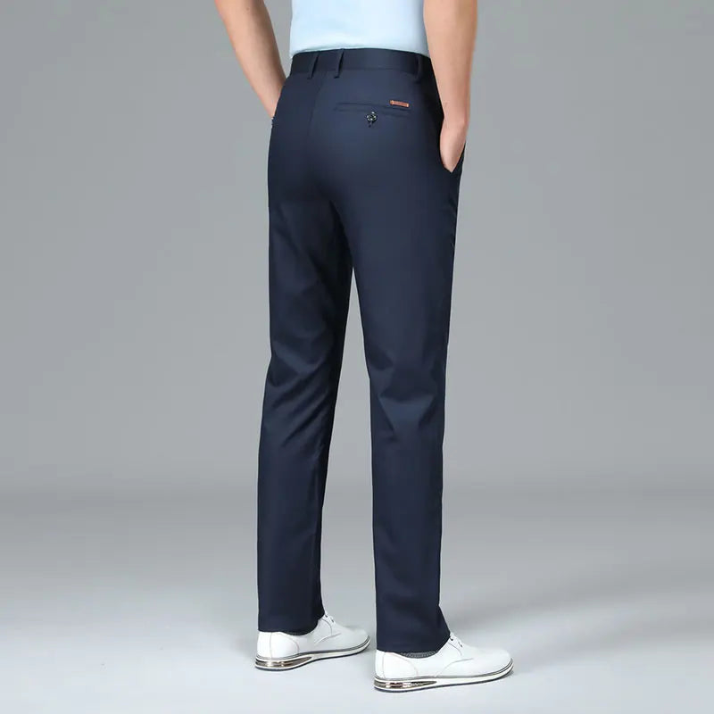 Navy blue pants worn by a person on a gray background