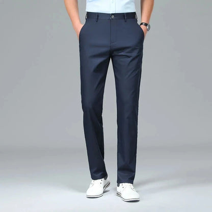 Person wearing navy blue dress pants on a gray background