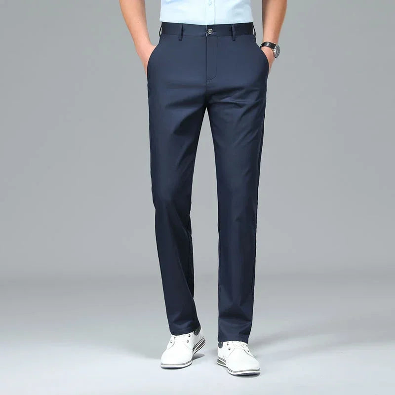 Person wearing navy blue dress pants on a gray background