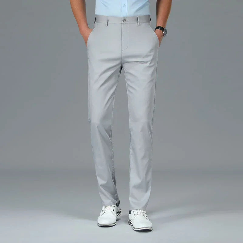 Person wearing light gray dress pants on a plain background