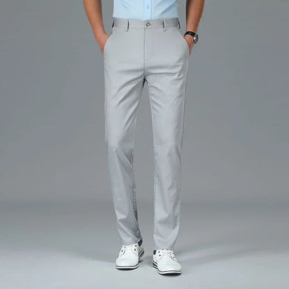 Person wearing light gray dress pants on a plain background